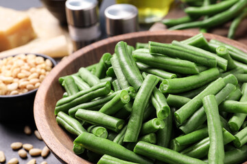Fresh raw green beans and other ingredients for salad on table, closeup