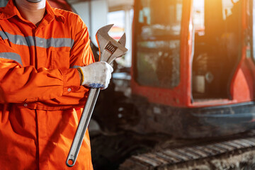 close up hand of excavator repair technician with large iron wrench in a hand, Powerful Professional Mechanic. Heavy Duty Equipment Maintenance. Industrial Concept. © tong2530
