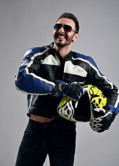 Portrait of happy laughing bearded man biker motocross race winner in sunglasses, motorcycle gear...