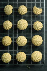 Homemade butter cookies on a wire rack and on the table, top down and vertical view.
