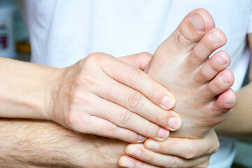 Foot Pain Leg of man sitting on white background and holding he feet and stretch the muscles i .Health care and spa concept.