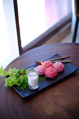 Thai dessert (Chor Phaka Kong) and Coconut milk on a black plate.