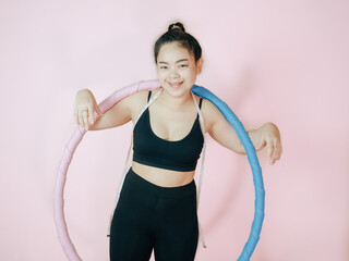 Lose belly fat concept from close up woman in sportswear and exercise with hula hoop for healthier body.