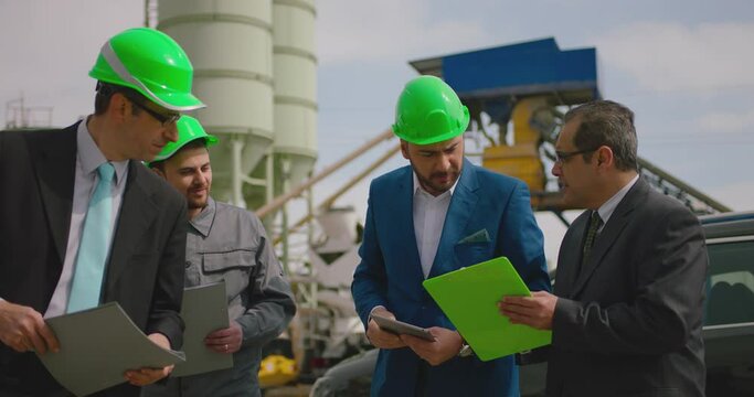 Construction workers, architect, businessman look over plans and discuss. Manager, contractors and foreman discussing or planing work. Group of workers with hard hat and document. Shot on ARRI camera.