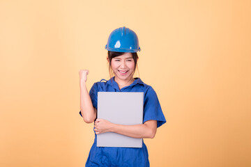 Young Asian female engineer working deliberately isolated on yellow background.	