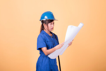 Young Asian female engineer working deliberately isolated on yellow background.