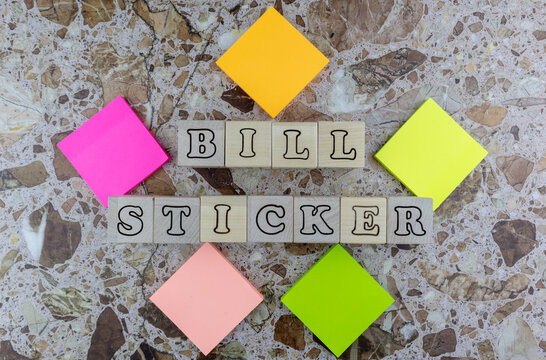 Biller Sticker concept with brightly colored memo pads forming a frame around wooden cubes with alphabet letters viewed top down on marbled stone