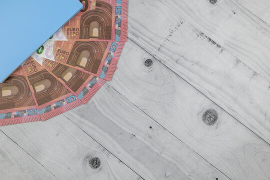 Financial, business, wealth or money background with fanned Euro banknotes in an upper corner and copyspace over diagonal white wooden boards in a flat lay still life. Top view