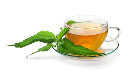 Glass cup of aromatic nettle tea and green leaves on white background