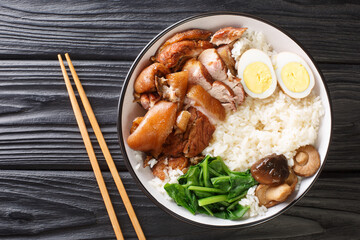 Authentic Thai Recipe for Braised Pork Leg kao kha moo closeup in the bowl on the table. horizontal...