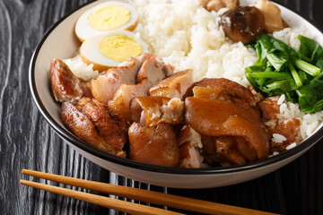 Authentic Thai Recipe for Braised Pork Leg kao kha moo closeup in the bowl on the table. horizontal