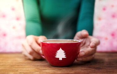 Christmas Concept. Woman Relaxing a Holidays Season by Hot Coffee Latte Indoors. focused on Christmas Tree