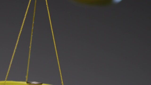 Yellow jewelry retro weigher . The scales are unsteady until they balance . Symbol of justice . Weights on the scales . Studio shot on RED EPIC Cinema Camera with strobe light