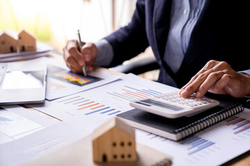 business woman calculating monthly home expenses, taxes, bank account balance, and credit card bills payment, Income is not enough for expenses.