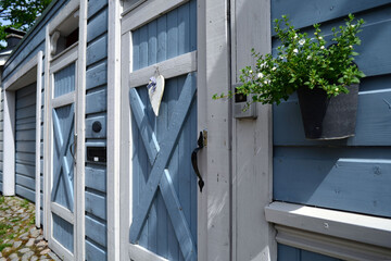 Wooden blue gate, hanging planters with flowers.