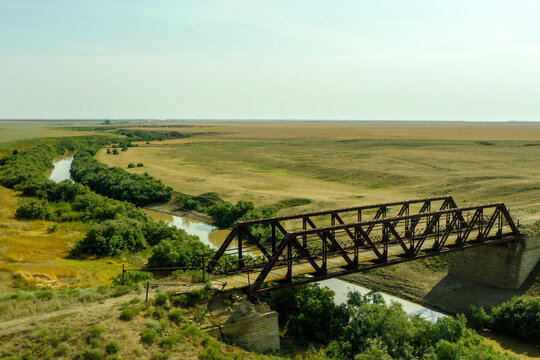 an old iron bridge over a river in the steppe on a country road a picture from a drone
