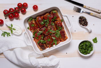 Flat lay with baked cabbage rolls in white square baking pan