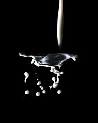 Splashes of white milk isolated on a black background.