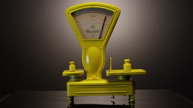 Working vintage weigher with arrow . The scales are unsteady until they balance . Measurement instrument in kilogram for food weight control . Studio shot on RED EPIC Cinema Camera with strobe light .