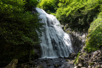 Fototapeta na wymiar Irina Waterfall in the Republic of Abkhazia. A clear sunny day on May 20, 2021