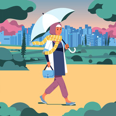 Obraz premium hijab woman walking in the park holding an umbrella on a cloudy day, park and cityline as background
