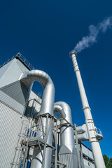 Biofuel boiler chimneys on a blue sky background.  Electrostatic precipitator in the foreground
