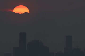 Heavy wildfire smoke surrounds Seattle with sunset behind the Olympic Mountains
