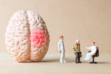 Miniature people Surgeon spoke with patient about brain injuries. World Stroke Day concept.

