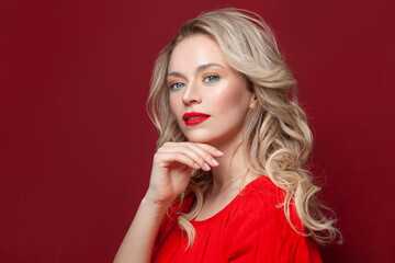 Beauty portrait of cute blond female face with natural skin on red