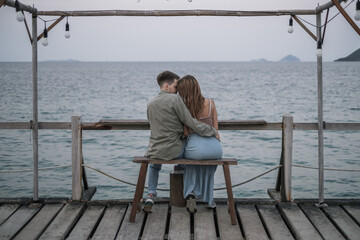 Lovely young couple enjoying honeymoon by the sea. Foreheads touch. Wearing casual clothes. High quality photo