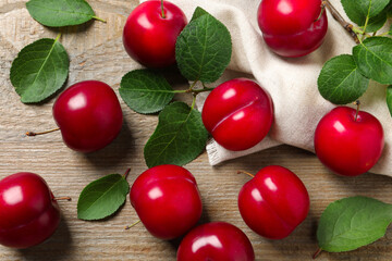 Fresh ripe cherry plums on wooden table, flat lay