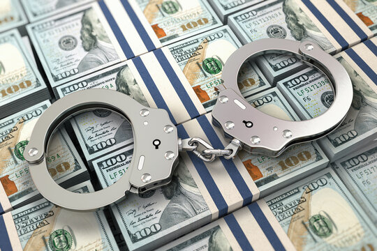 Handcuffs on dollar packs. Illegal money, corruption and bribe concept.