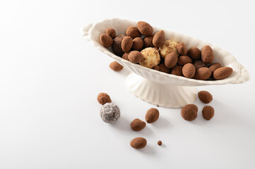 natural chocolate truffles in decorative dishes, white background, empty space for text