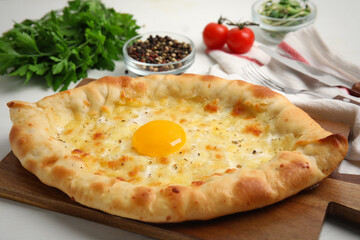 Fresh delicious Adjarian khachapuri on white table, closeup