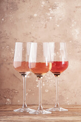 Rose wine glasses on the beige table. Rosado, rosato or blush wine tasting concept, negative space