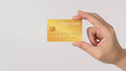 Hand is holding gold credit card isolated on white background.