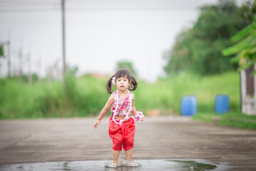 Close-up background view of a blurred Asian girl running or teasing in the street in front of the...