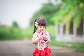 Fototapeta premium Close-up background view of a blurred Asian girl running or teasing in the street in front of the house, doing activities together outside the classroom during the holidays.