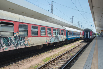 Fototapeta na wymiar Passenger train with graffiti at the train station in the city. Railway station