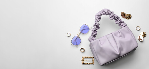 Stylish woman's bag, sunglasses and bijouterie on light background, flat lay