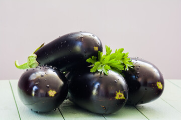 Fresh ripe eggplants on a white wooden table