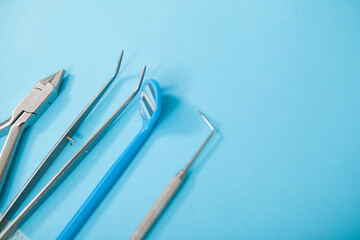 Close up of sterile dentists tools on blue background, copy space