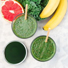 Healthy green smoothie with kale, chlorella, banana and grapefruit detox drink, square format, top view