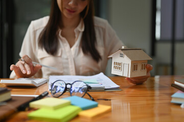 Fototapeta premium Closed up with real estate agent holding a house model, real estate broker agent working, mortgage loan offer for and house insurance.
