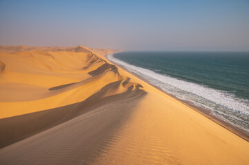Fototapeta na wymiar Surreal natural landscape of desert and sea. The topography of the Atlantic coast of Africa. Areas with scarce water resources. Popular travel destination in Namibia.