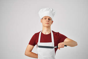 male chef in a white apron Frying pan in hand cooking food