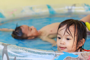 In the Summer season. Asian children swimming and playing in the the water pool.
