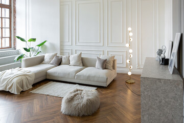 minimalistic interior of an ultra modern open plan apartment with white and gray walls with a relief and gray stylish upholstered furniture and huge windows