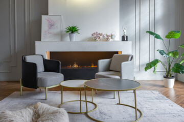 minimalistic interior of an ultra modern open plan apartment with white and gray walls with a relief and gray stylish upholstered furniture and huge windows