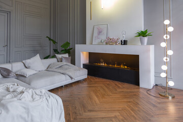 minimalistic interior of an ultra modern open plan apartment with white and gray walls with a relief and gray stylish upholstered furniture and huge windows